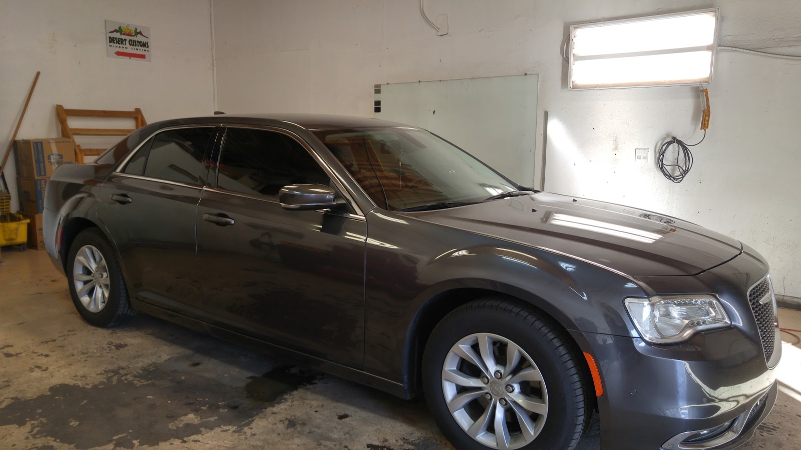 Gray Chrysler 300 with tinted windows inside the Desert Customs tint shop