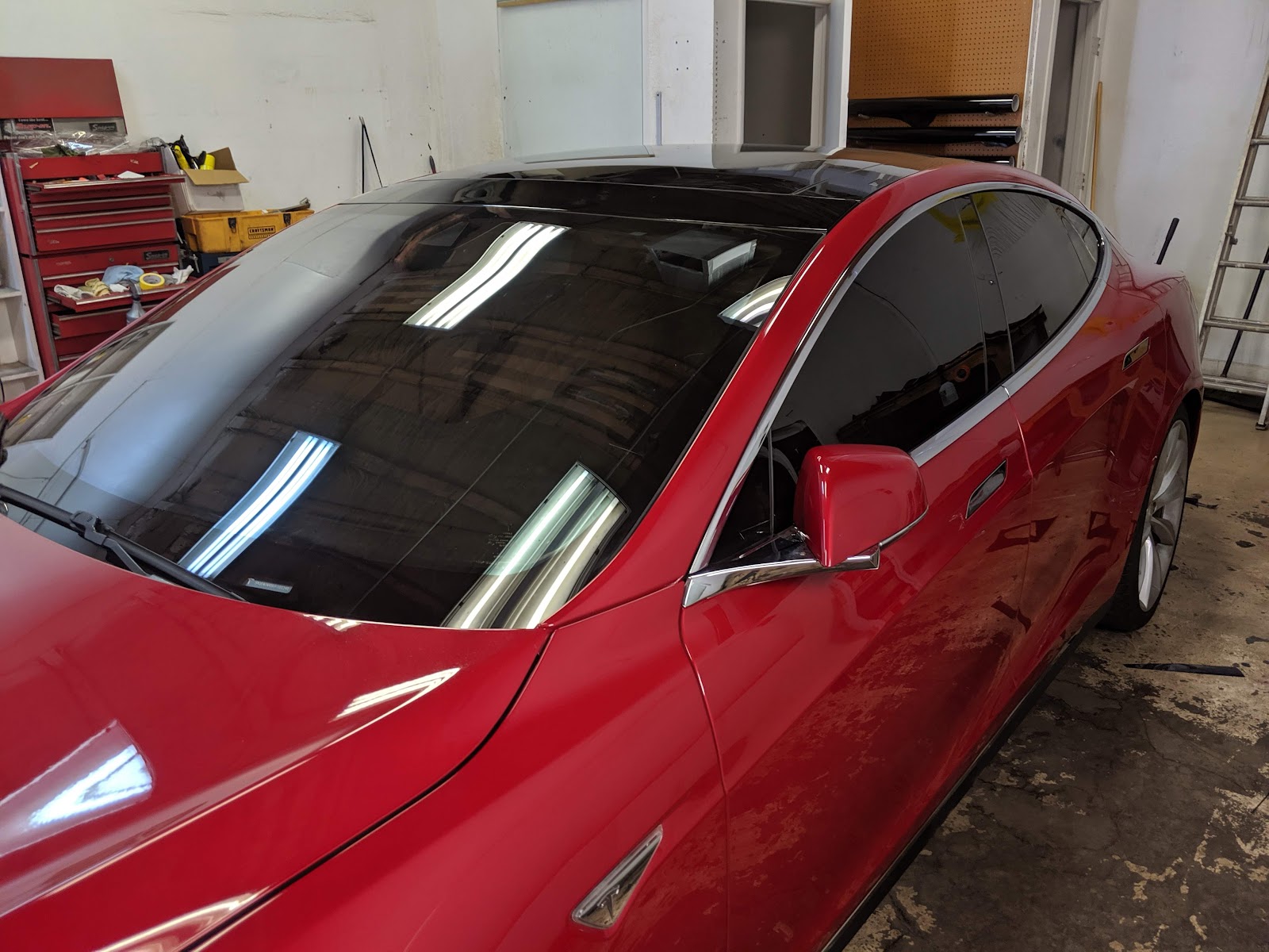 Red Tesla Model S with freshly tinted windows inside the Desert Customs tint shop
